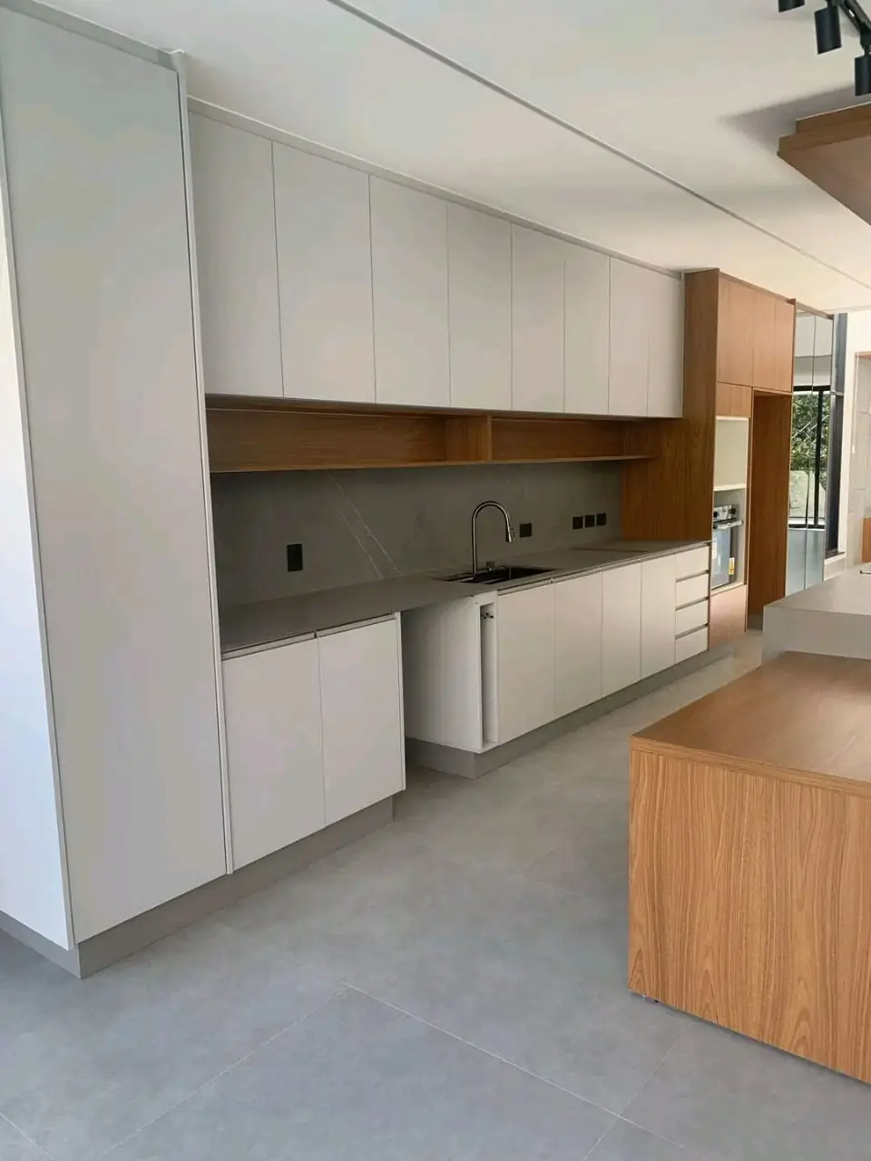 Cozinha planejada branca com nichos e ilha em madeira